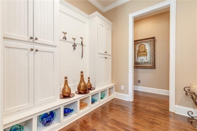 mudroom featuring ornamental molding, dark wood-type flooring, and baseboards