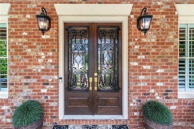 entrance to property featuring french doors and brick siding