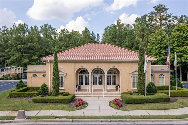 mediterranean / spanish home featuring a tile roof