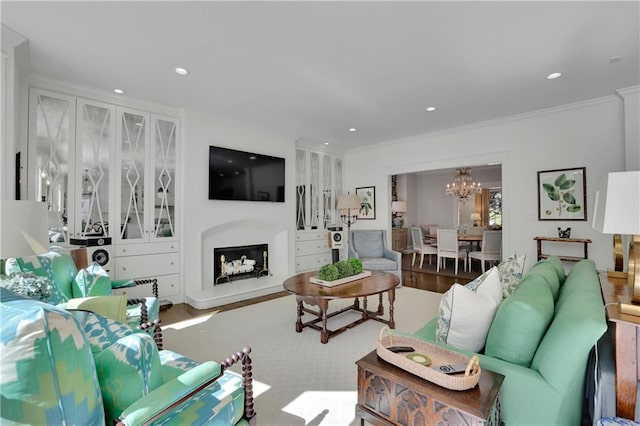 living room with ornamental molding, wood-type flooring, and a notable chandelier