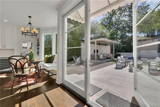 sunroom with ceiling fan with notable chandelier and french doors