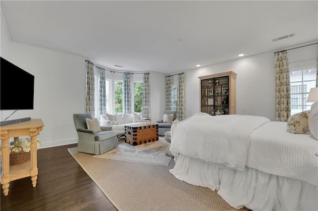 bedroom featuring multiple windows and dark hardwood / wood-style floors