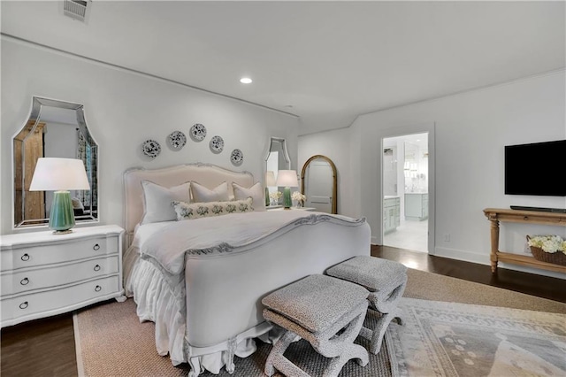 bedroom featuring dark hardwood / wood-style flooring and connected bathroom