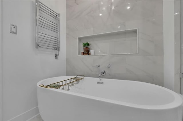 bathroom with a tub to relax in and radiator heating unit