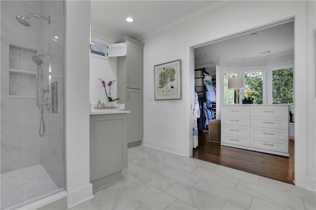 bathroom featuring vanity, crown molding, and tiled shower