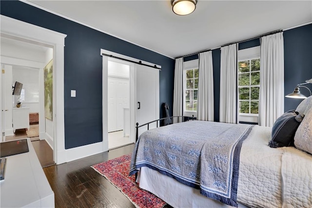 bedroom with a barn door, dark hardwood / wood-style flooring, and a closet