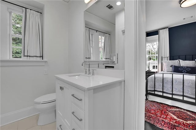 bathroom featuring vanity, tile patterned flooring, a wealth of natural light, and toilet