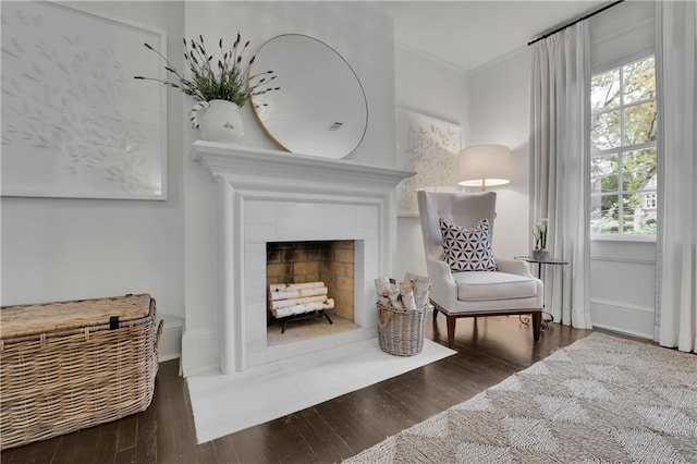 living area featuring a fireplace, plenty of natural light, dark hardwood / wood-style floors, and ornamental molding