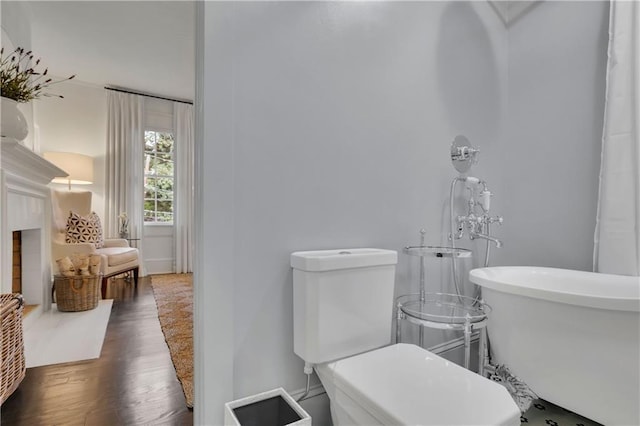 bathroom featuring hardwood / wood-style flooring, a tub, and toilet