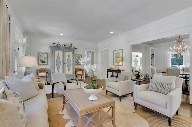 living room featuring crown molding, a chandelier, and light hardwood / wood-style flooring