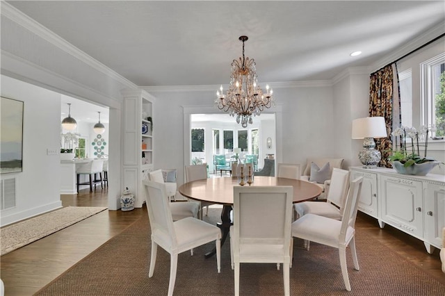 dining room with a notable chandelier, crown molding, and dark hardwood / wood-style floors