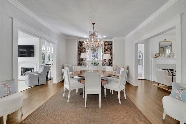 dining space featuring hardwood / wood-style floors, ornamental molding, and a healthy amount of sunlight