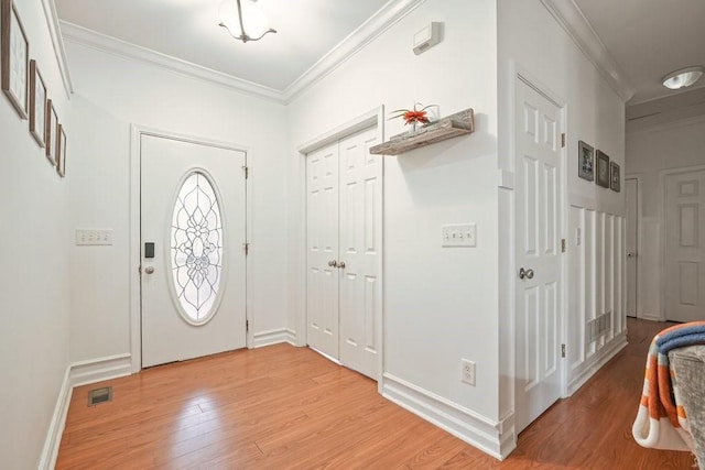 foyer featuring crown molding, baseboards, and light wood-type flooring
