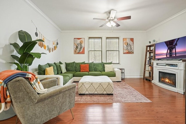 living room featuring ornamental molding, ceiling fan, and wood finished floors