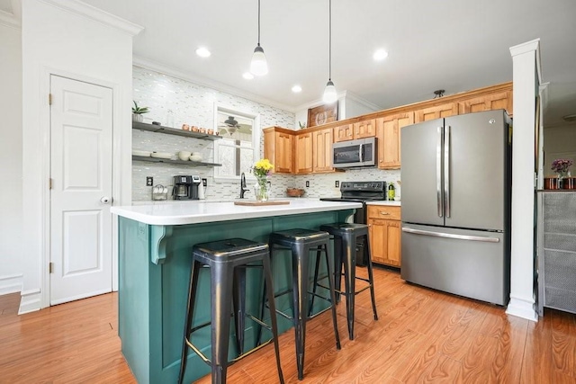 kitchen featuring a breakfast bar area, light countertops, light wood finished floors, ornamental molding, and stainless steel appliances