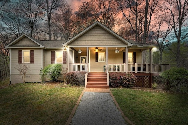 view of front facade with a porch, crawl space, a ceiling fan, and a front yard