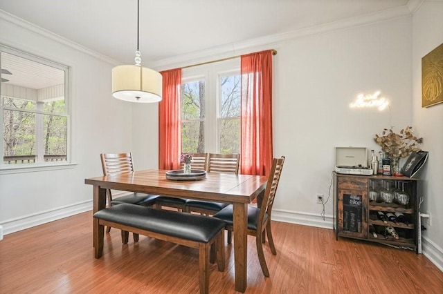 dining room featuring baseboards, ornamental molding, and wood finished floors