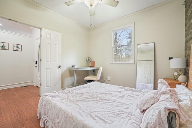 bedroom with a closet, ornamental molding, ceiling fan, and wood finished floors
