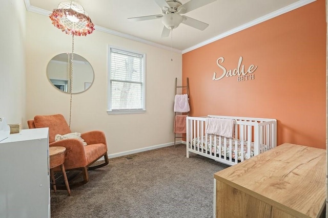 bedroom with carpet floors, ornamental molding, baseboards, a nursery area, and a ceiling fan