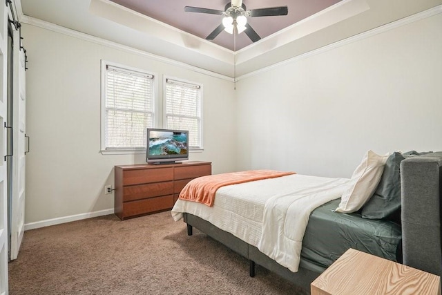 bedroom featuring a raised ceiling, ornamental molding, light carpet, and a ceiling fan