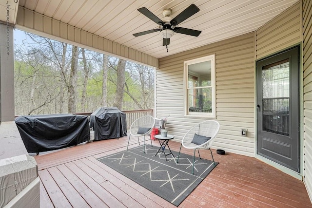 wooden deck with a ceiling fan and a grill