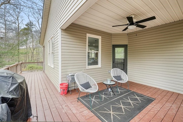 wooden deck featuring grilling area and a ceiling fan