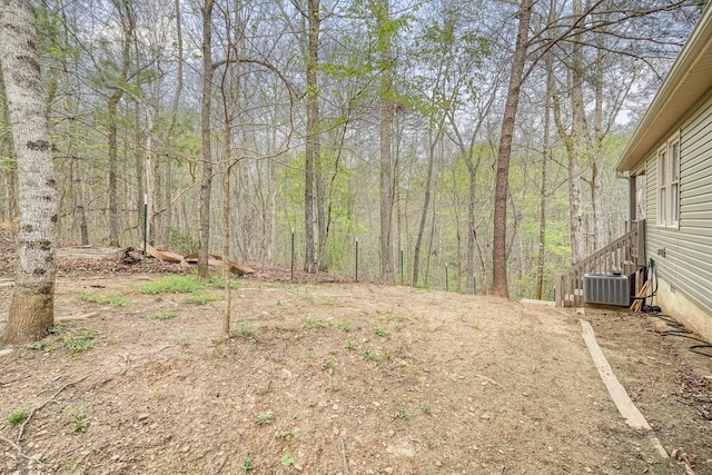 view of yard with a view of trees and central AC