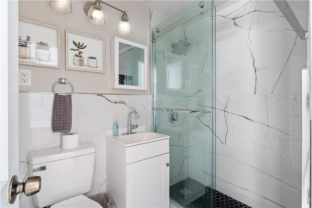 bathroom with backsplash, toilet, vanity, a shower with shower door, and tile walls