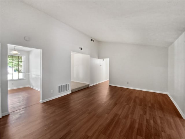 empty room with dark hardwood / wood-style flooring and high vaulted ceiling