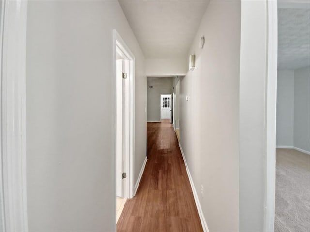 hallway with hardwood / wood-style floors