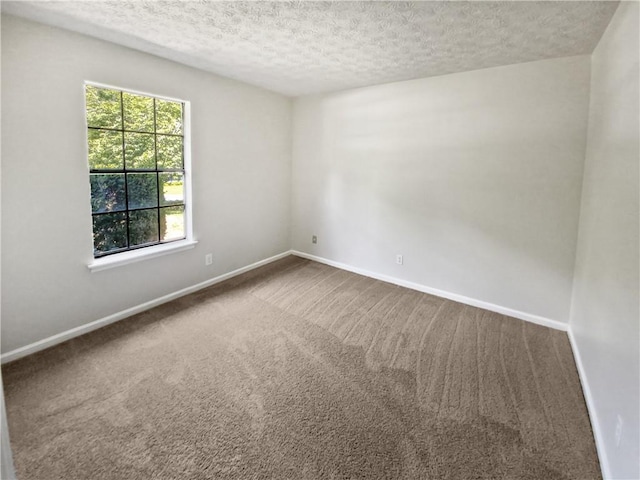 carpeted spare room with a textured ceiling