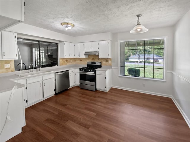 kitchen with sink, stainless steel appliances, dark hardwood / wood-style flooring, decorative light fixtures, and white cabinets