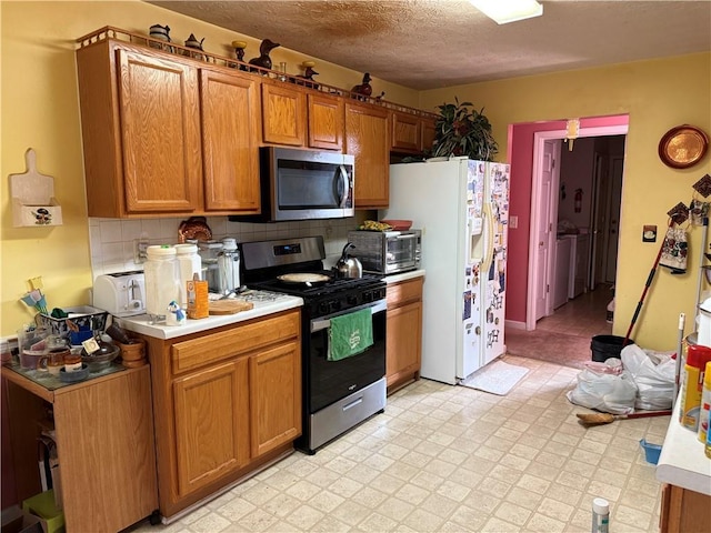 4206 Shoreside Cir, Snellville, GA 30039 - kitchen featuring appliances with stainless steel finishes, light countertops, brown cabinets, backsplash, and a textured ceiling