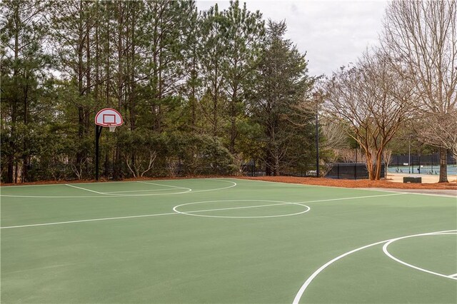 view of tennis court featuring basketball hoop