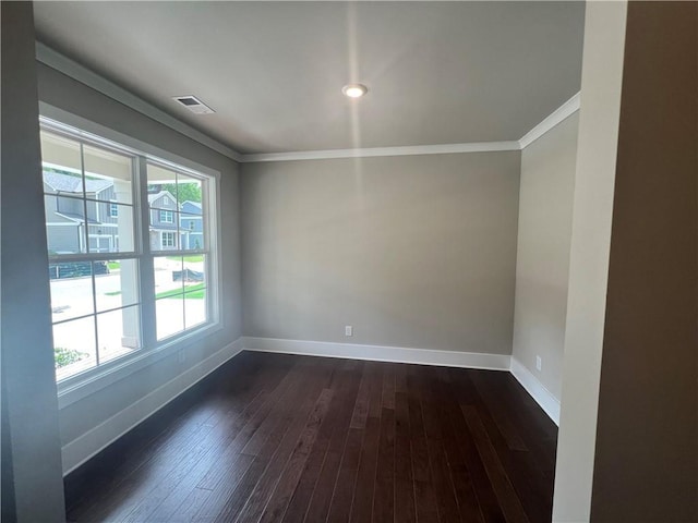 empty room with dark hardwood / wood-style flooring and crown molding