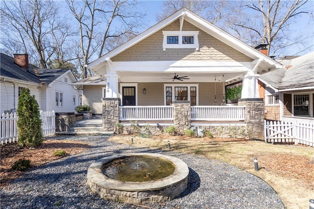 craftsman house featuring covered porch, ceiling fan, and fence