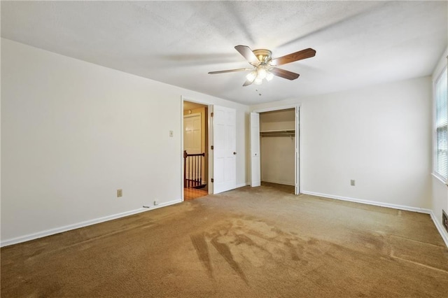 unfurnished bedroom featuring ceiling fan, carpet floors, a closet, and baseboards