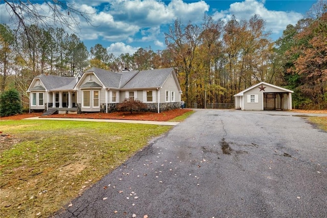 ranch-style house featuring an outbuilding and a front lawn