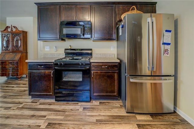 110 Baltusrol Way, Covington, GA 30014 - kitchen featuring black appliances, light wood-style floors, light countertops, and dark brown cabinets