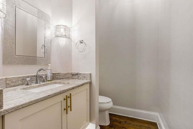 bathroom with vanity, toilet, and wood-type flooring