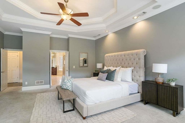 carpeted bedroom featuring a raised ceiling, ceiling fan, and ornamental molding