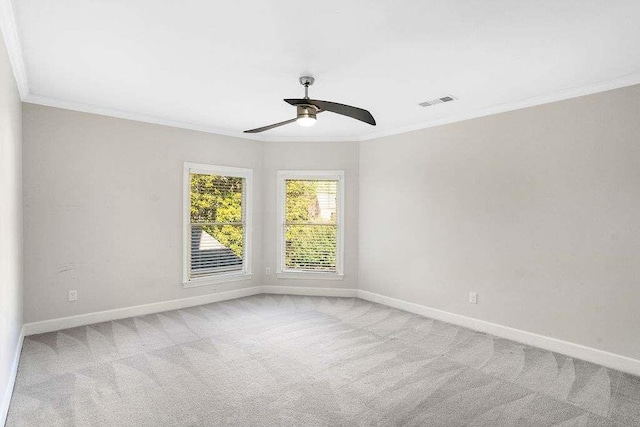 empty room featuring ceiling fan, ornamental molding, and light carpet