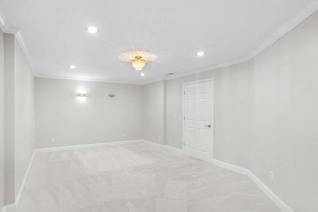 carpeted spare room featuring crown molding