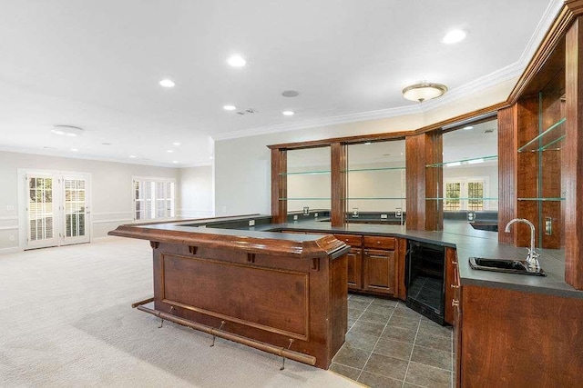 kitchen featuring wine cooler, sink, dark carpet, and ornamental molding