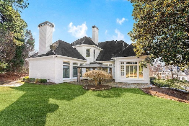 rear view of house with a gazebo and a yard