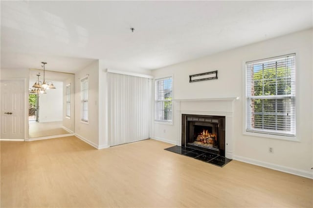 5638 River Heights Xing SE, Marietta, GA 30067 - unfurnished living room featuring a healthy amount of sunlight, a lit fireplace, and wood finished floors