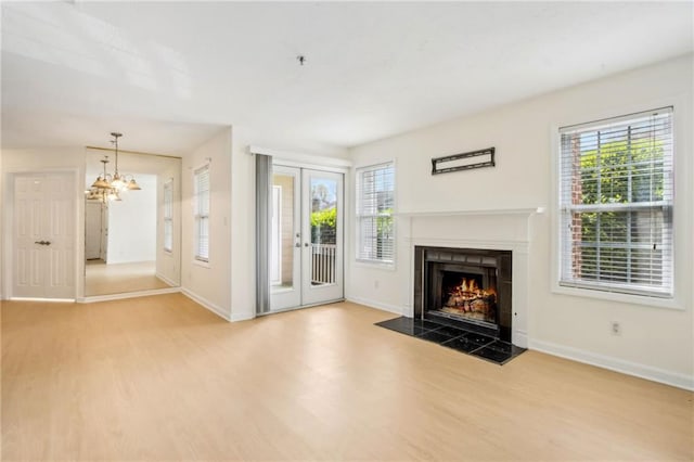 5638 River Heights Xing SE, Marietta, GA 30067 - unfurnished living room featuring a chandelier, wood finished floors, baseboards, and a lit fireplace