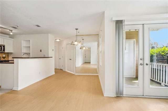 5638 River Heights Xing SE, Marietta, GA 30067 - kitchen with white cabinetry, visible vents, stainless steel microwave, dark countertops, and light wood finished floors
