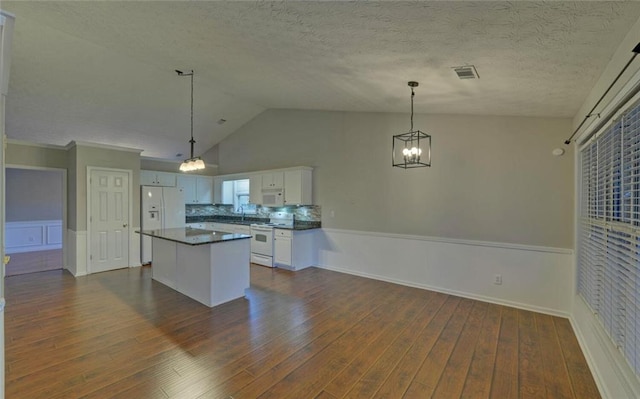 kitchen featuring dark wood finished floors, wainscoting, dark countertops, white cabinetry, and white appliances
