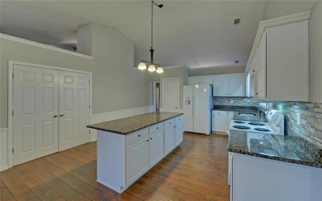 kitchen featuring white cabinets, tasteful backsplash, a kitchen island, white fridge with ice dispenser, and ornamental molding